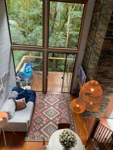 a living room with a couch and a patio with a pool at Cabana Gato do Mato in São Francisco de Paula