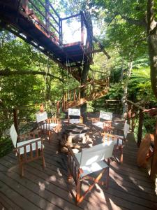 a wooden deck with chairs and a fire pit at Treeful Treehouse Sustainable Resort in Nago