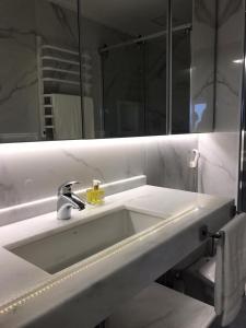 uma casa de banho com um lavatório branco e um espelho. em Q-Flat Hotel - Faria Lima em São Paulo