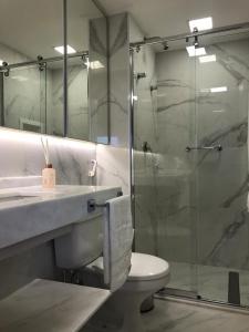 uma casa de banho com uma cabina de duche em vidro e um WC. em Q-Flat Hotel - Faria Lima em São Paulo