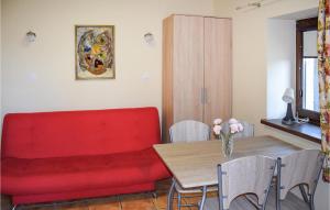 a living room with a red couch and a table at Beautiful Apartment In Rydzewo With Kitchen in Rydzewo