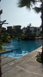 a swimming pool in a resort with palm trees at Mayan Vidanta PLAYA departamento REMODELADO 2 y 3 recámaras in Acapulco