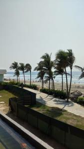 - une plage avec des palmiers et l'océan dans l'établissement Mayan Vidanta PLAYA departamento REMODELADO 2 y 3 recámaras, à Acapulco