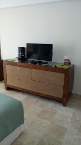 a wooden dresser with a television on top of it at Mayan Vidanta departamento 2 recámaras CON SERVICIO DE PLAYA in Acapulco