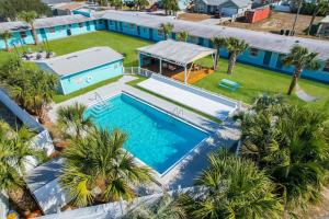 an overhead view of a swimming pool with palm trees at Renovated Studio - Steps to Beach, POOL, & Cabana! in Panama City Beach