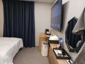 a hotel room with a bed and a flat screen tv at Hotel Sono in Incheon