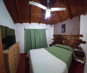 a bedroom with a bed and a ceiling fan at Cabañas Tres Ríos Vacacional in Villa Cura Brochero