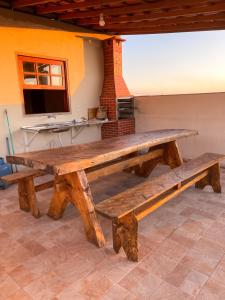 a large wooden table in a room with a kitchen at Casa Por do Sol. in São Thomé das Letras