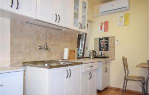 a kitchen with white cabinets and a sink at Nice Apartment In Rydzewo With Wifi in Rydzewo