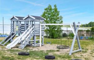 a playground with a slide and swings at Nice Apartment In Rydzewo With Wifi in Rydzewo