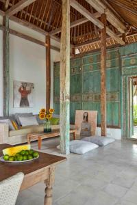 uma sala de estar com paredes verdes e uma mesa em Bennu House em Ubud