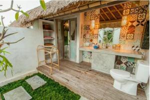 a bathroom with a toilet on a wooden deck at Bennu House in Ubud