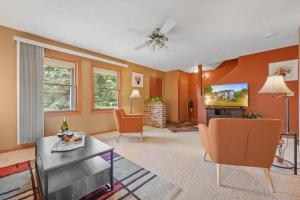 a living room with orange walls and a table and chairs at LONG LAKE RETREAT- Hot tub, Pool table, Firepit in Traverse City