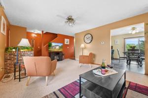 a living room with a table and chairs and a tv at LONG LAKE RETREAT- Hot tub, Pool table, Firepit in Traverse City