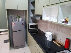 una pequeña cocina con nevera y microondas en Alpine Conezion Golf View Netflix at IOI City Mall, en Putrajaya