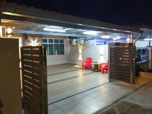 a patio with two red chairs and a table at My 23 Homestay in Muar