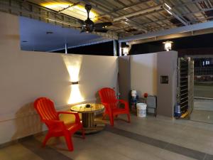 a room with three red chairs and a table at My 23 Homestay in Muar