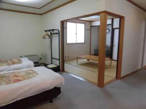 a hotel room with two beds and a mirror at Asakusa Sanso in Uonuma