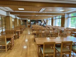 una cafetería vacía con mesas y sillas de madera en Asakusa Sanso en Uonuma