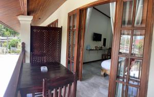 a room with a wooden table and a bedroom at Villa KhounSok Sunset in Luang Prabang