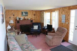 sala de estar con sofá y silla en Point Field en Deer Isle