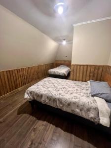 two beds in a room with wooden walls at Casa Recinto in Recinto