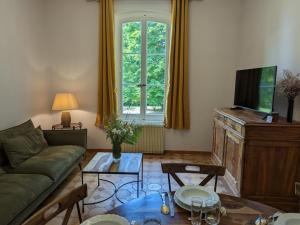 a living room with a couch and a tv at Gîte Chadurie, 4 pièces, 4 personnes - FR-1-653-233 in Chadurie