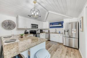 a kitchen with white cabinets and a large counter top at Charming Modern 3BR Fresno House in Fresno