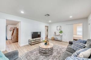 a living room with a couch and a tv at Charming Modern 3BR Fresno House in Fresno