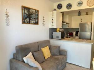 ein Wohnzimmer mit einem Sofa und einer Küche in der Unterkunft Appartement Le Lavandou, 2 pièces, 4 personnes - FR-1-308-181 in Le Lavandou