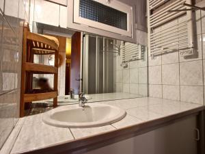 a bathroom with a white sink and a mirror at Appartement Chamrousse, 2 pièces, 6 personnes - FR-1-340-271 in Chamrousse