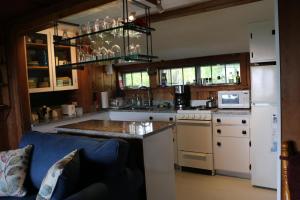 uma cozinha com electrodomésticos brancos e um sofá azul em Shipshape em Stonington