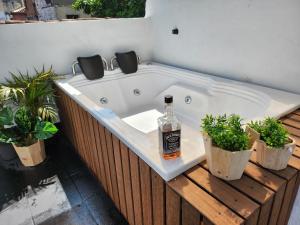 eine Flasche Alkohol in einer Badewanne mit Pflanzen in der Unterkunft PRADO DOWNTOWN in Medellín