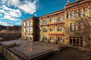 ein großes Backsteingebäude mit vielen Fenstern in der Unterkunft Hotel Alpine Ladakh in Leh