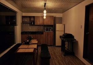 eine Küche mit einem Tisch und einem Kühlschrank in der Unterkunft Finca La Piedra in Aquitania