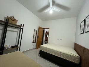 a bedroom with a bed and a ceiling fan at Rafael Apartamentos 800m da Praia da Maranduba in Ubatuba