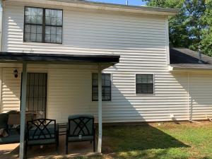 ein weißes Haus mit zwei Stühlen auf der Veranda in der Unterkunft Cozy - Home Away From Home with Free Parking in Atlanta