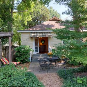 Casa blanca pequeña con mesa y sillas en Urban Cottages en Little Rock