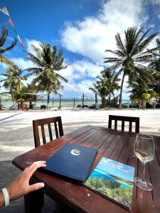 eine Person, die an einem Tisch am Strand mit einem Laptop sitzt in der Unterkunft Hotel Luna De Plata in Mahahual