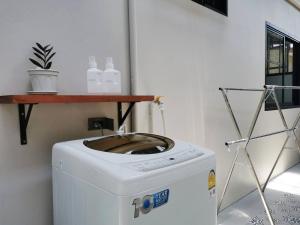 a washing machine in a room with a shelf on top of it at How Hide Space in Kanchanaburi