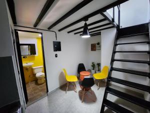 a room with a staircase and chairs and a bathroom at PRADO DOWNTOWN in Medellín
