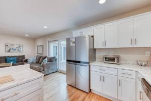 a kitchen with white cabinets and a living room at The Happy Hideaway 1BR Unit in Fresno