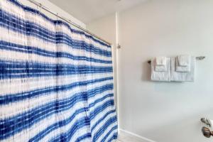 baño con ducha con cortina azul y blanca en The Happy Hideaway 1BR Unit en Fresno