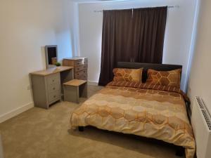 A Spacious and Hearty 2BD Swindon stay في سويندون: غرفة نوم مع سرير وخزانة ومكتب