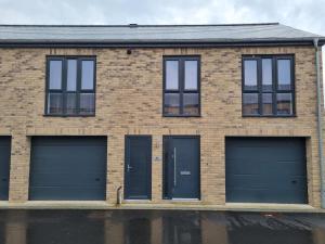 um edifício de tijolos com duas portas de garagem em A Spacious and Hearty 2BD Swindon stay em Swindon