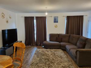 a living room with a couch and a television at A Spacious and Hearty 2BD Swindon stay in Swindon
