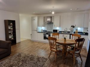 a kitchen and dining room with a table and chairs at A Spacious and Hearty 2BD Swindon stay in Swindon