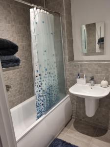 een badkamer met een douche en een wastafel bij A Spacious and Hearty 2BD Swindon stay in Swindon