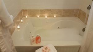 a bathroom with a bath tub with candles in it at Urban Cottages in Little Rock