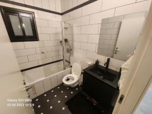 a bathroom with a toilet and a sink and a mirror at The Kingdom On The Beach in Bat Yam